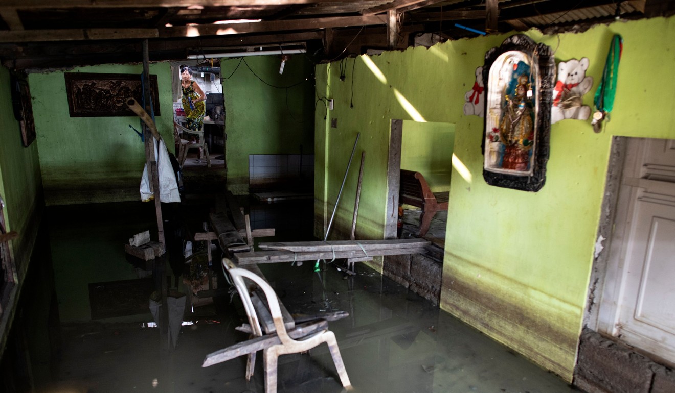 A woman inside a flooded house in Mabalacat, Pampanga. Photo: AFP
