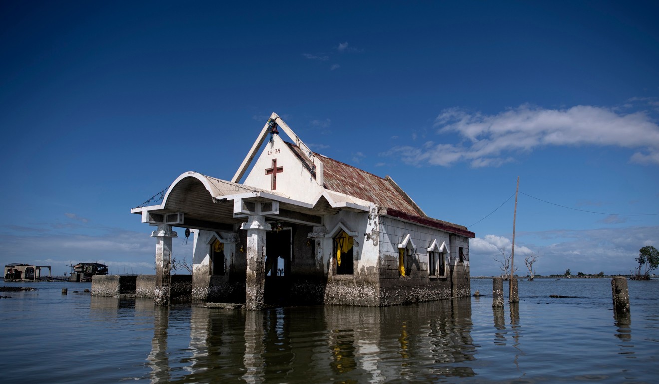 A chapel stands amid encroaching bay waters in Sitio Pariahan, Bulacan. Photo: AFP