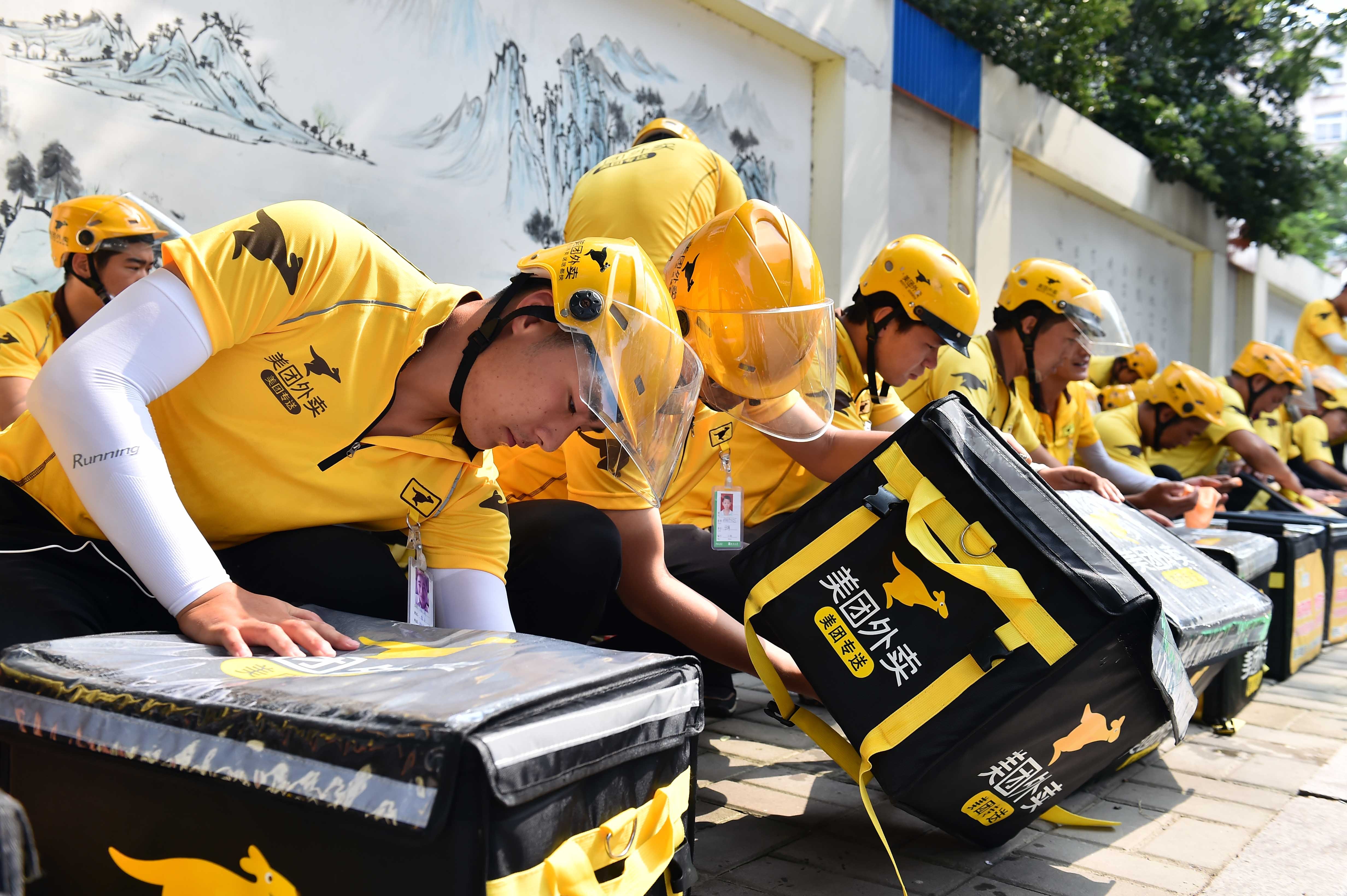 Deliverymen package the food they are going to deliver in Jinan, capital city of east China's Shandong Province, July 20, 2017. Photo: Xinhua