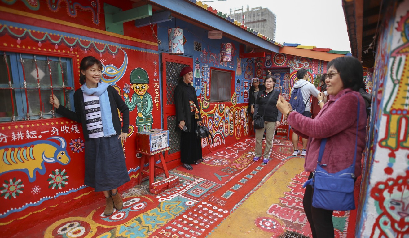 Tourists enjoy the artwork at Rainbow Village. Photo: Rachel Chung