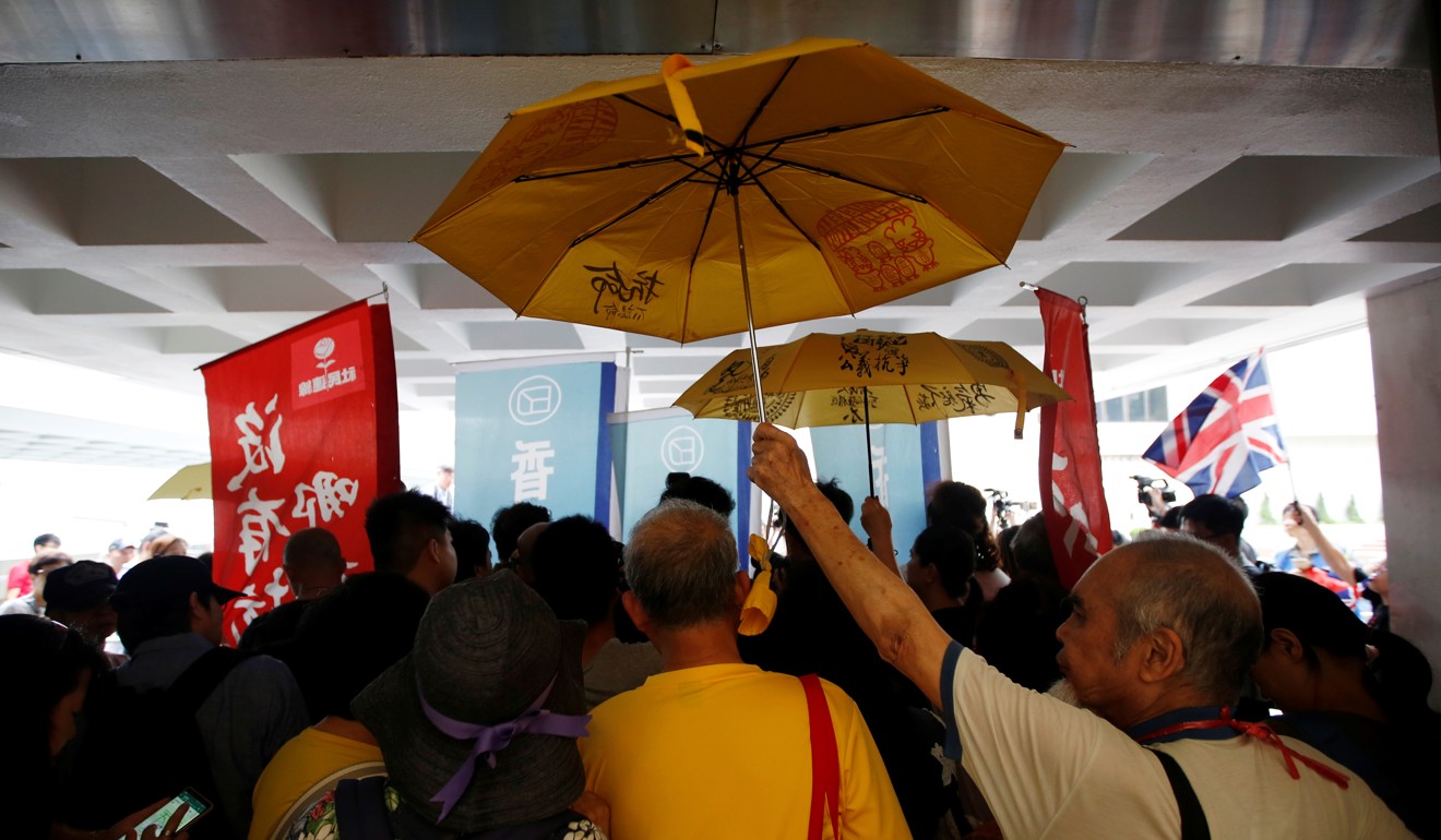 Activists hold umbrellas while listening to Wong speak at the High Court this month. Photo: Reuters