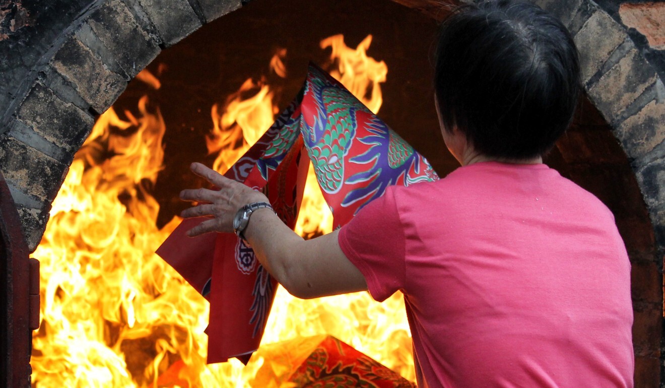 Paper offerings being placed into the fire at a Tin Hau temple. Photo: Dickson Lee