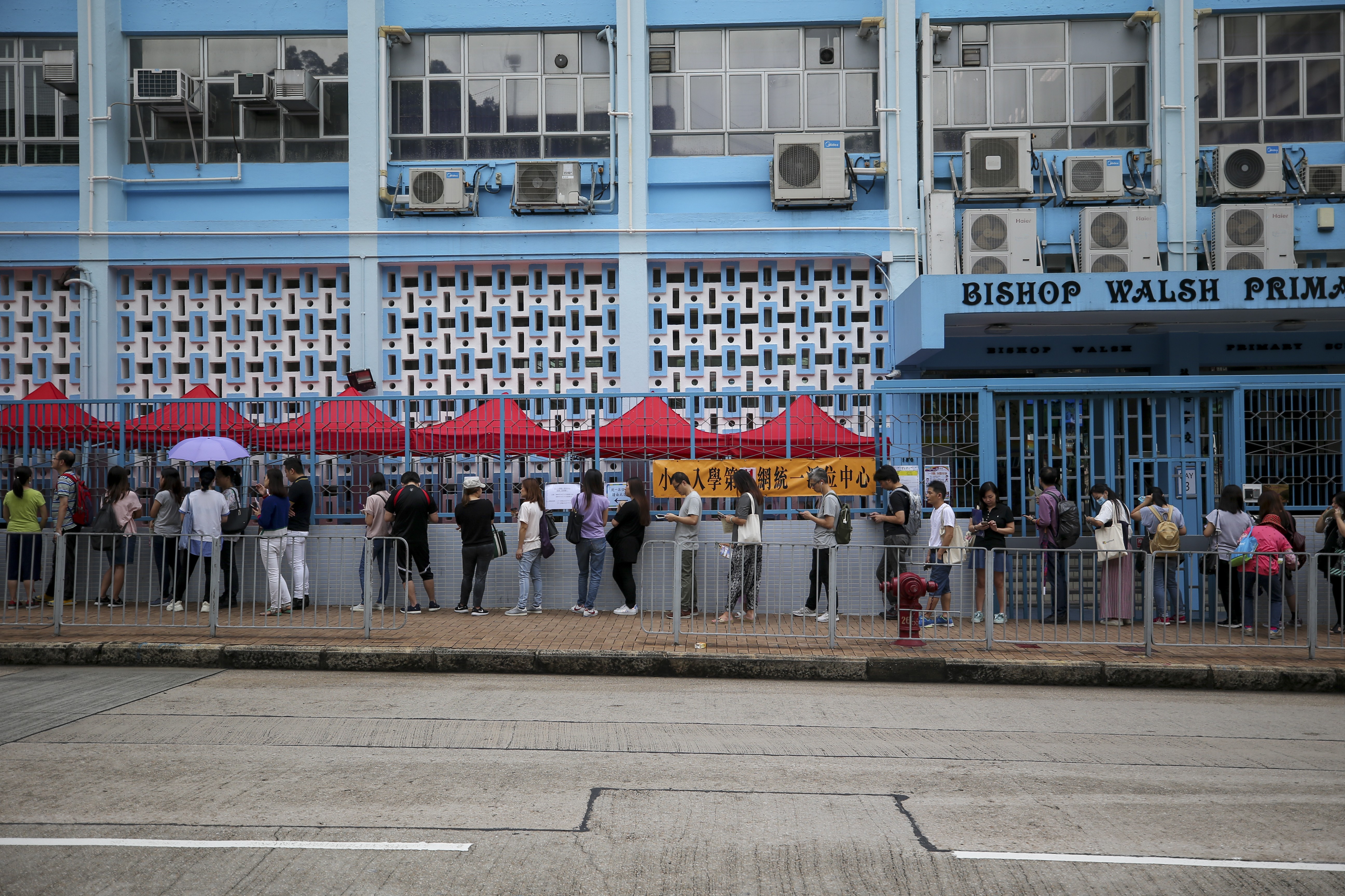 Parents wait for the Primary One allocations results at Bishop Walsh Primary School in Lok Fu, as families across the city try to secure what they see as improved places for their children at schools they were not admitted to. Photo: Winson Wong