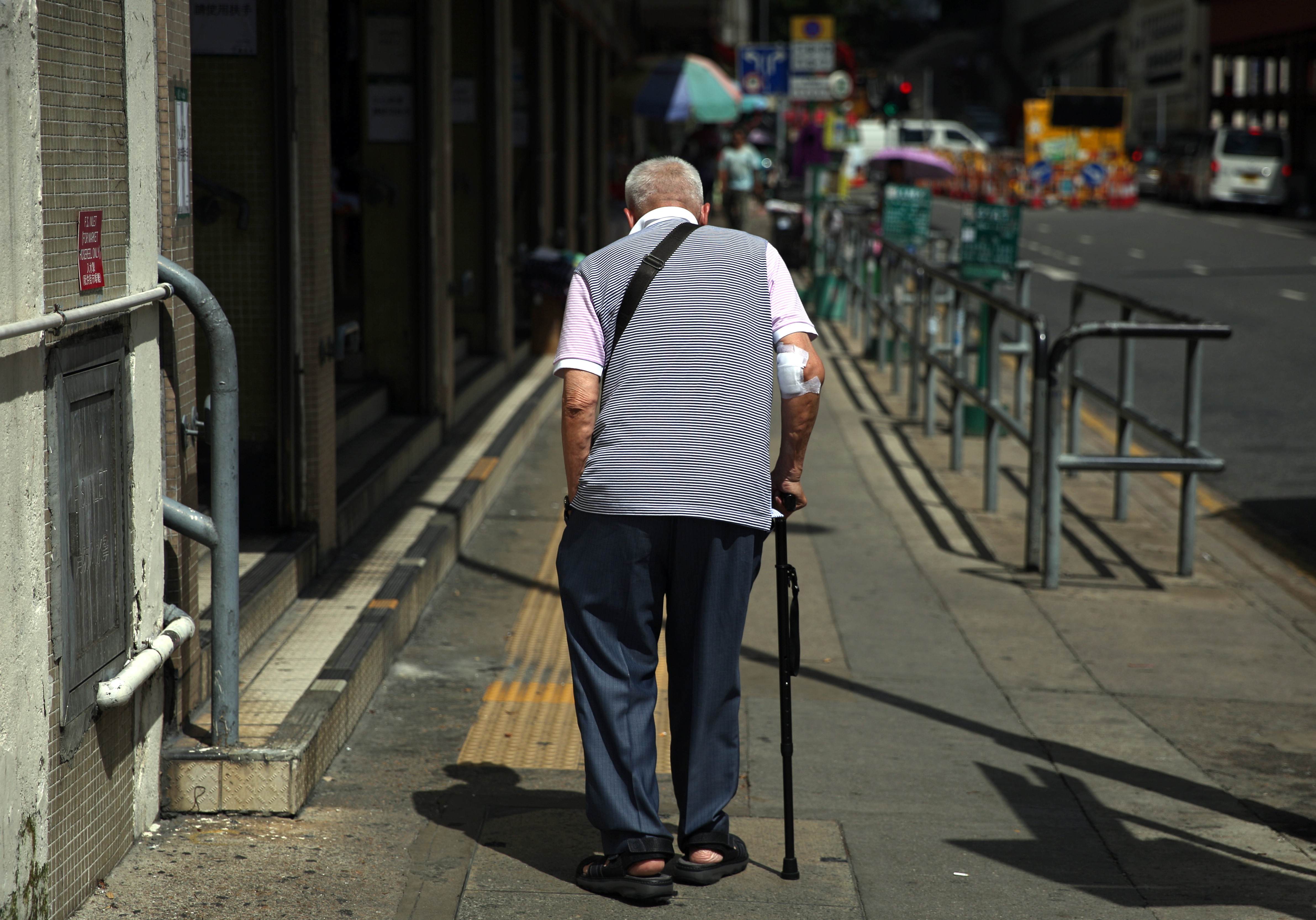 An elderly man walks along a street in Sham Shui Po. A new study has suggested there is a link between hot weather and suicide. Photo: Sam Tsang