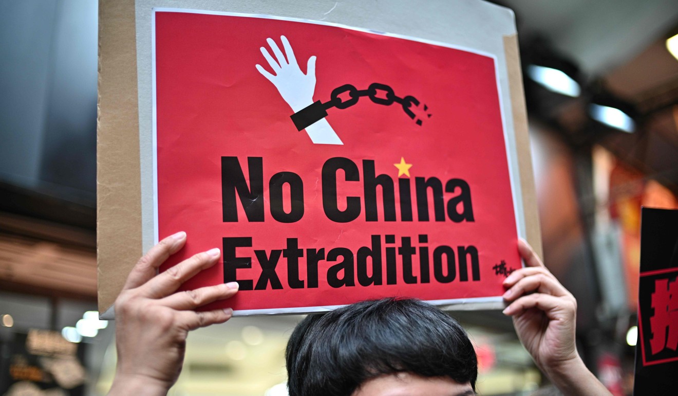 An activist holds a placard during a protest in April against a proposal by the Hong Kong government to hand over fugitives to mainland China, and other jurisdiction where it has no formal extradition agreement. Photo: AFP