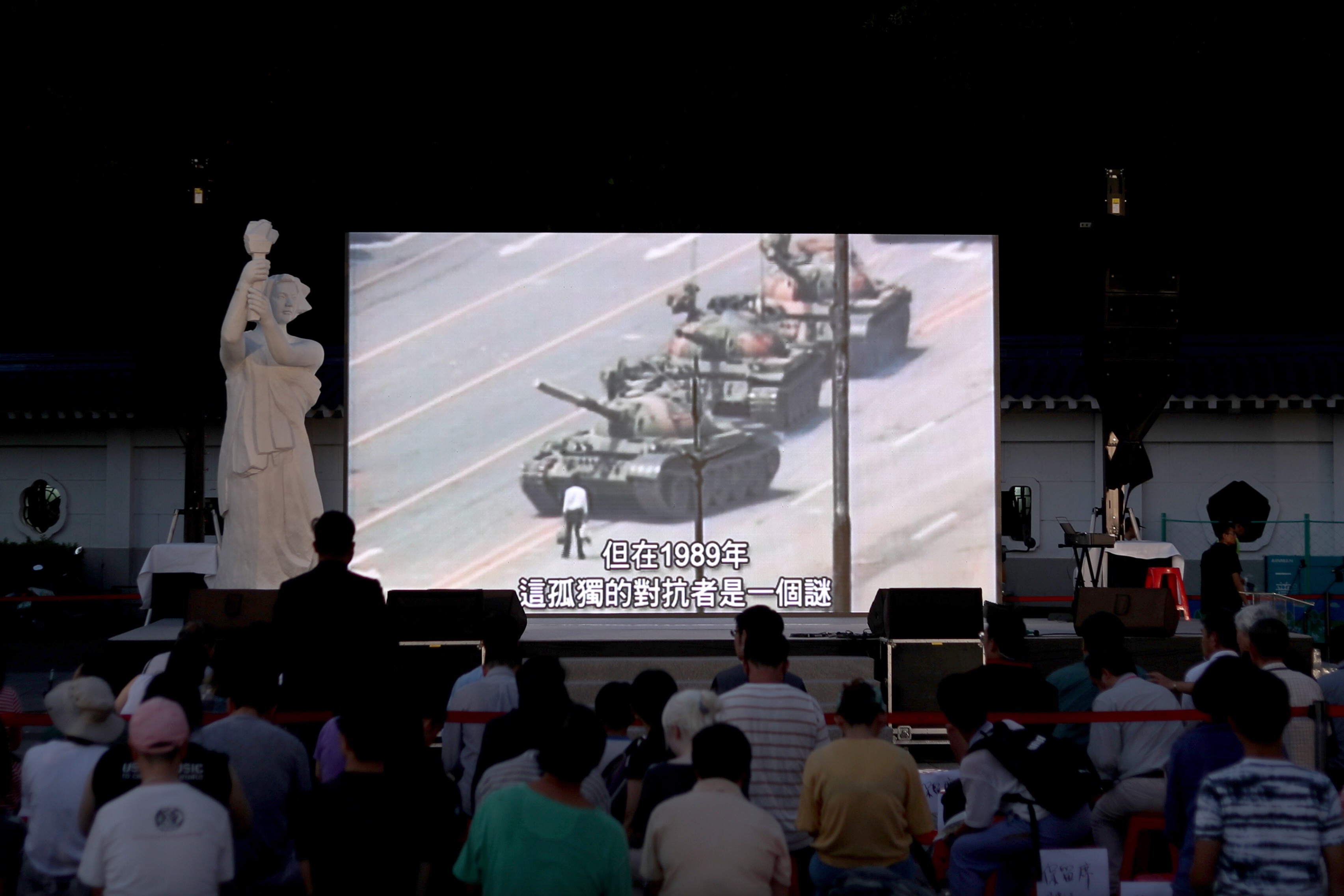 People watch a video showing ‘Tank Man’ at a vigil in Taipei on Tuesday. Photo: EPA-EFE