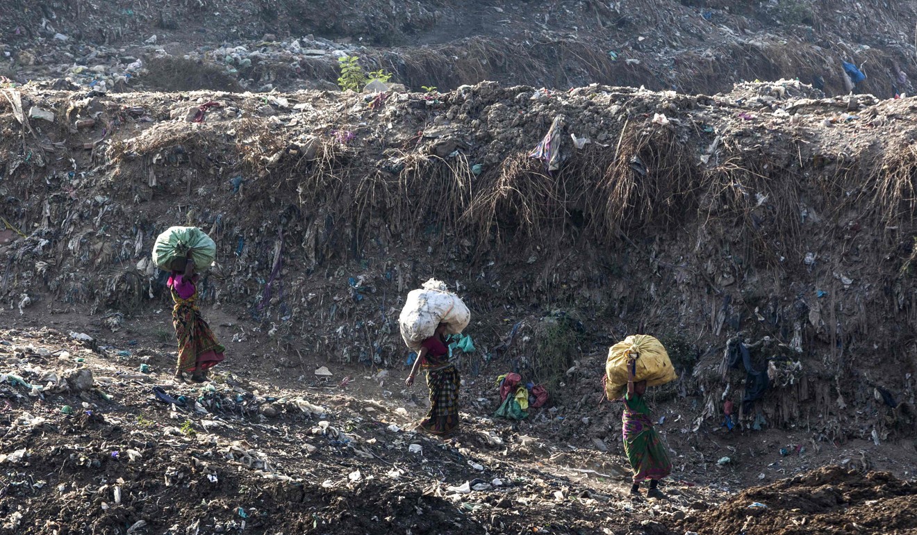 Rag pickers carry sacks of sorted recyclable materials at the Ghazipur landfill site. Photo: AFP