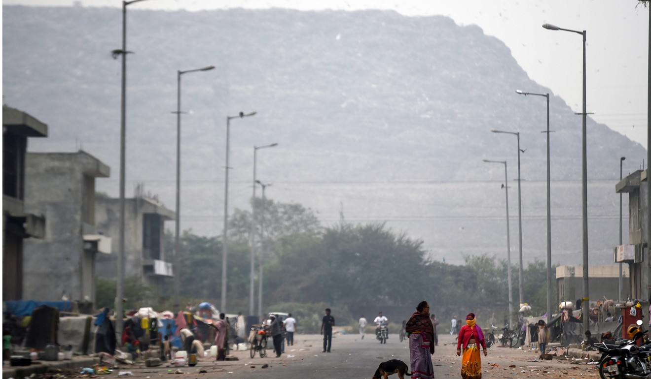 People walk towards the Ghazipur landfill site in New Delhi. Photo: AFP