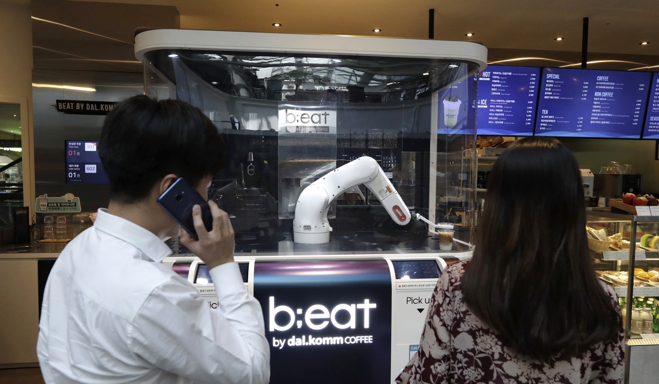 Customers wait for coffees in front of a robot named b;eat. Photo: AP