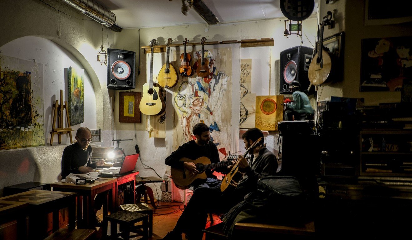 Two men play guitar during a jam session at the Tejo bar in Lisbon’s Alfama neighbourhood. Photo: AFP