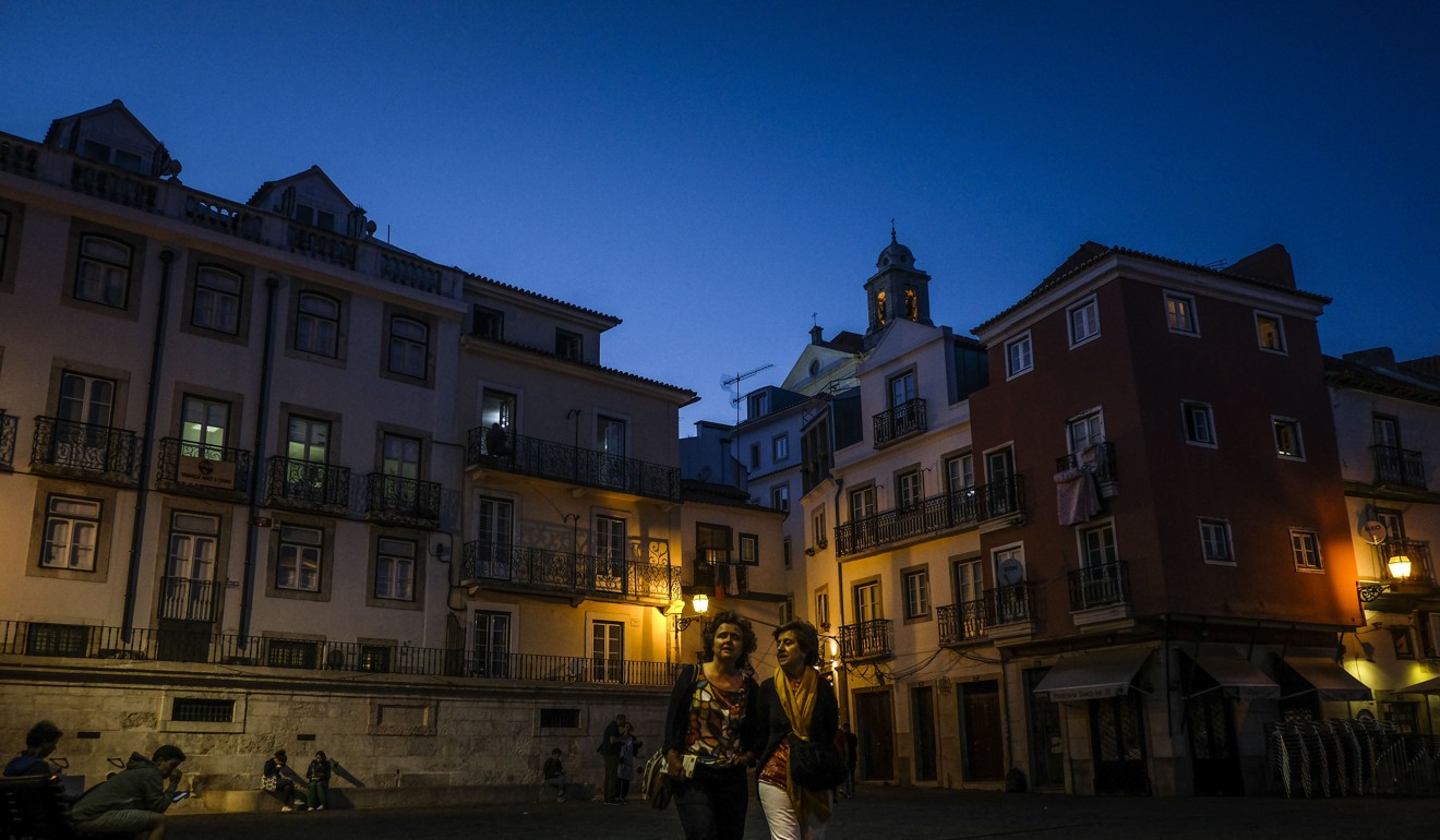 Two tourists take a walk through the Alfama neighbourhood in Lisbon. Photo: AFP