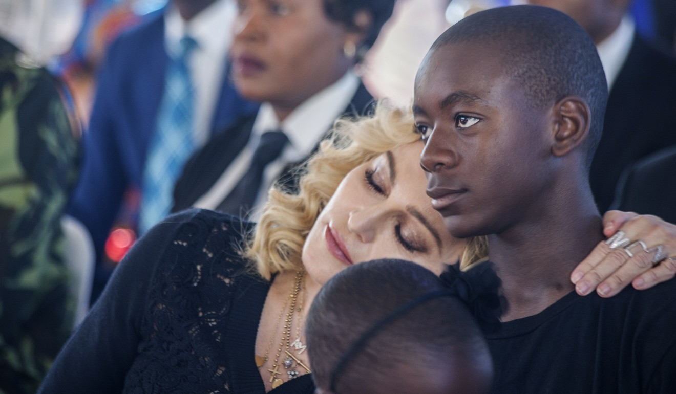 Madonna rests her head on the shoulder of her adopted son David Banda who is attending the Benfica football academy in Lisbon. Photo: AFP