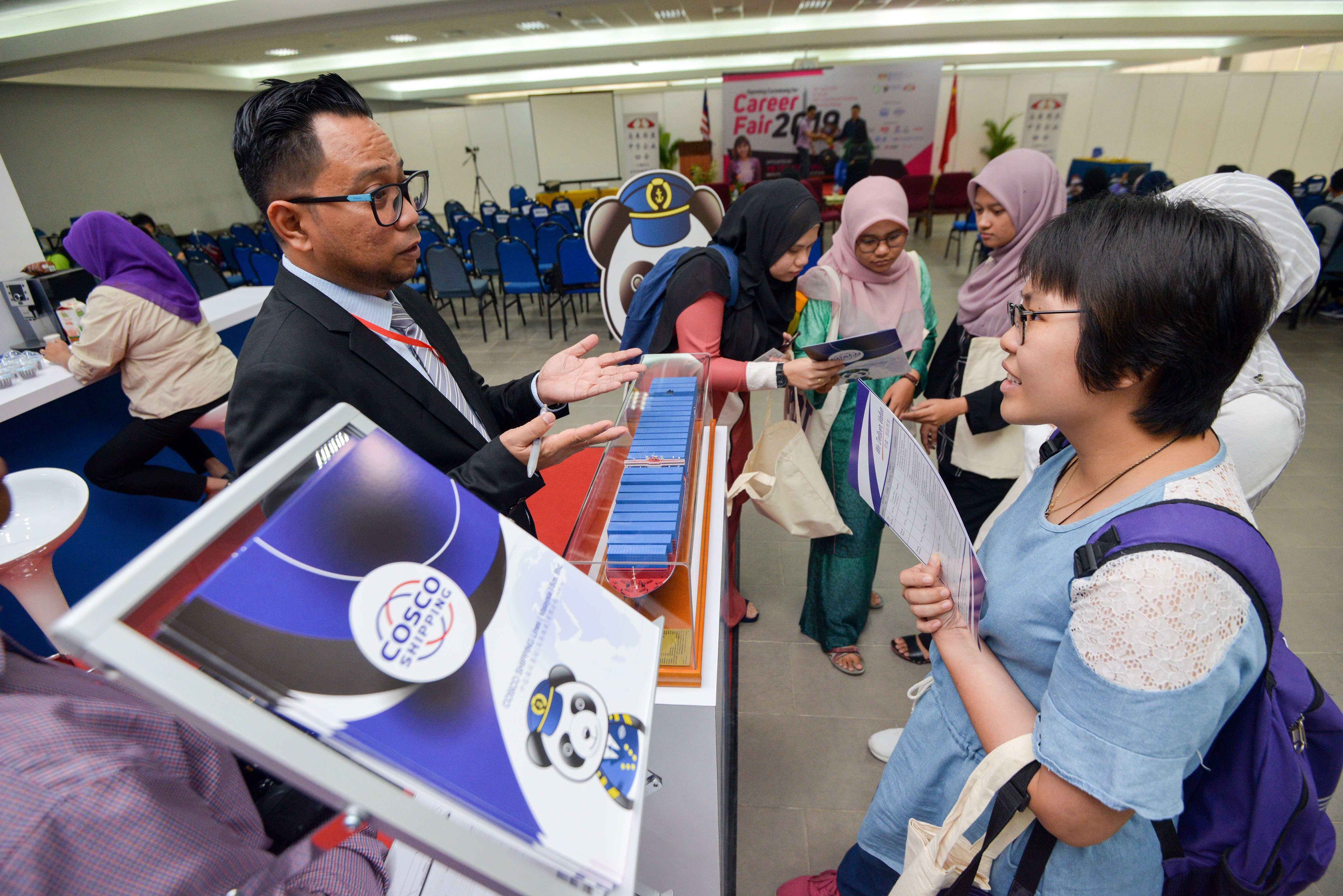 Job-seeking students talk to a representative of Cosco Shipping at a job fair of leading Chinese companies at the University of Malaya, in Kuala Lumpur, Malaysia, April 29, 2019. Photo: Xinhua