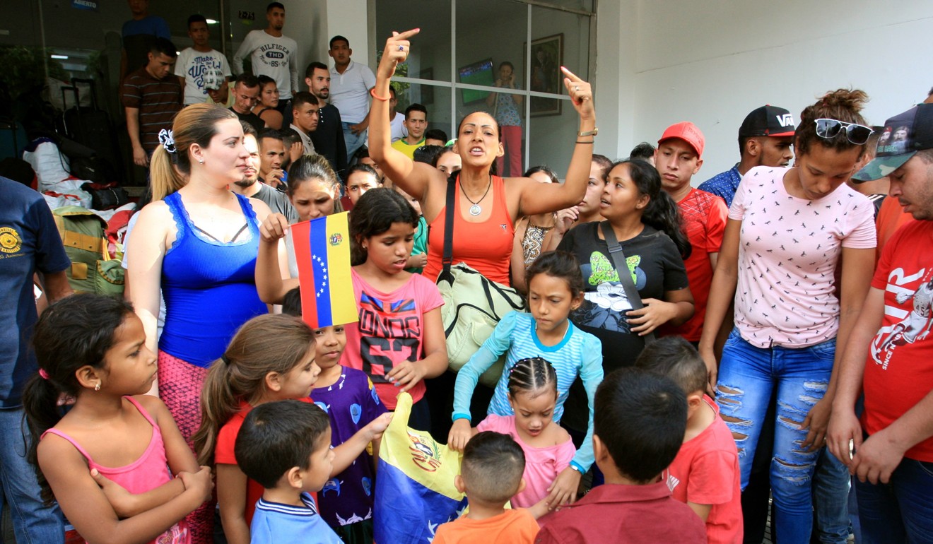 Former Venezuelan soldiers and their families, who are in Colombia as refugees, stand outside after being evicted from a hotel for not paying, in Cucuta. Photo: EPA-EFE