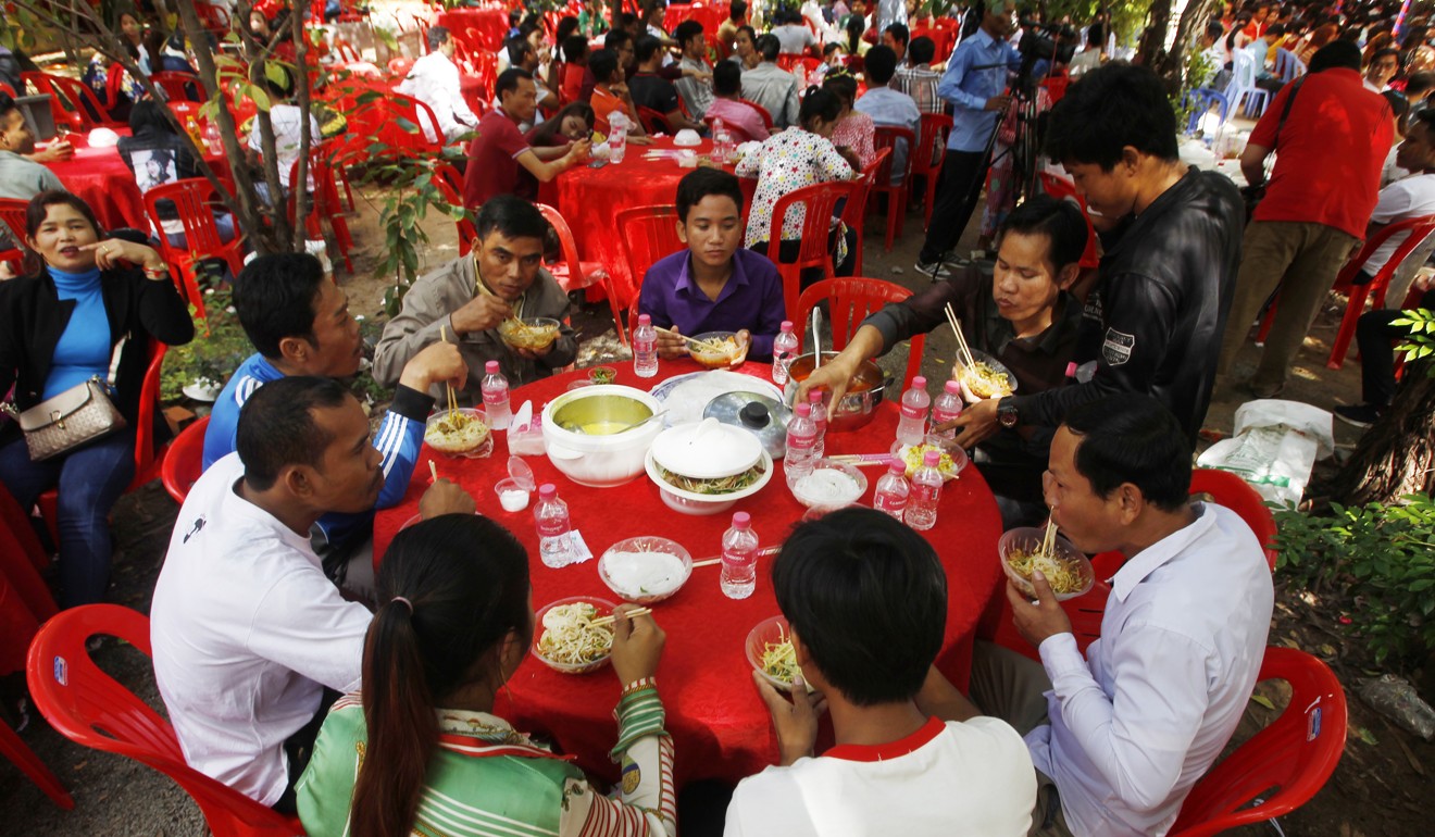 Cambodian garment workers eat noodles at a Buddhist pagoda at outside Phnom Penh. Photo: AP