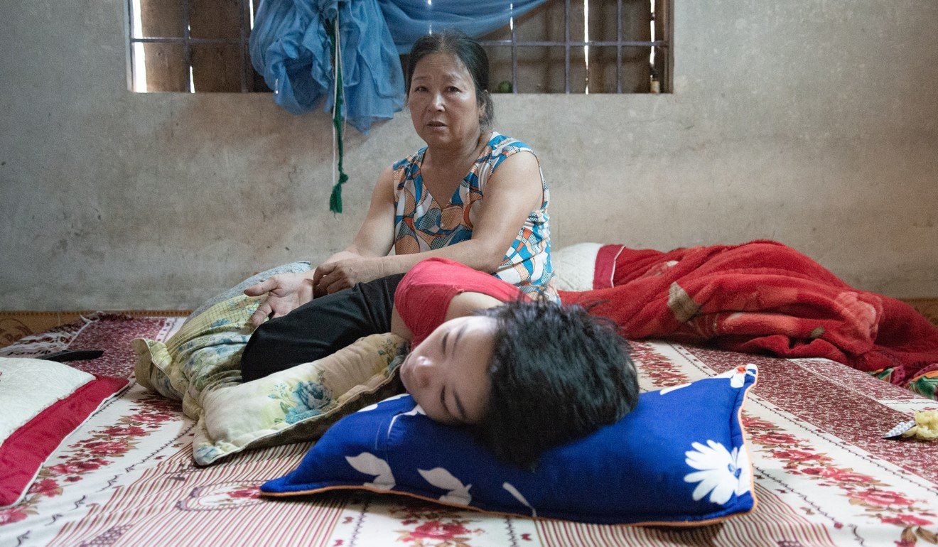 Nguyen Thi Thuy, 58, has cared for her severely disabled son, Tran Thi Hong, since the day he was born paralysed 26 years ago. Photo: Khairul Anwar