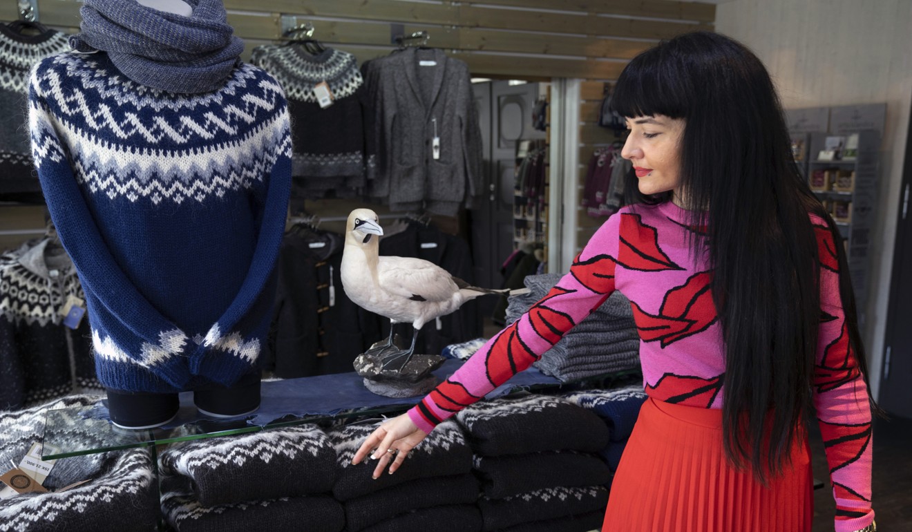 A sales assistant points to one of the jumpers in a story in Reykjavik. Photo: AP