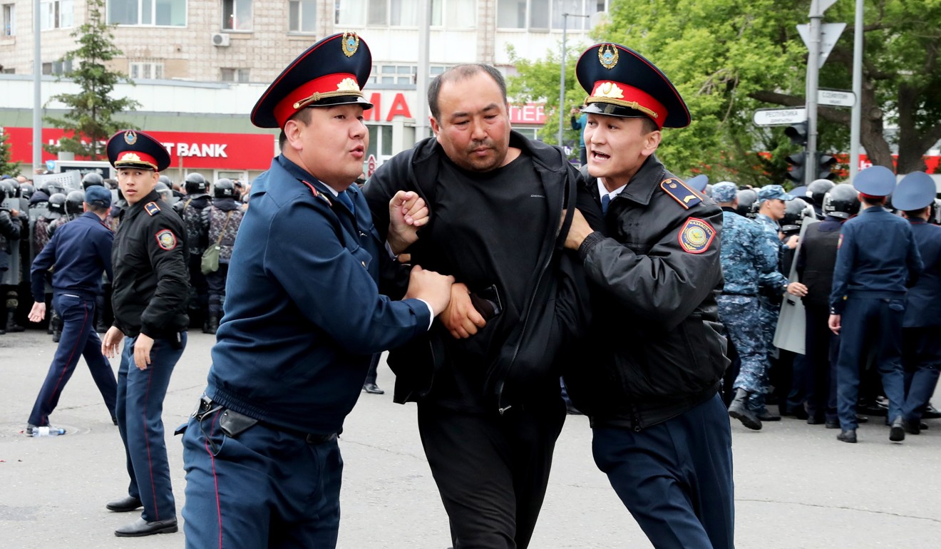 Police detain an opposition supporter during a protest on Sunday. Photo: EPA
