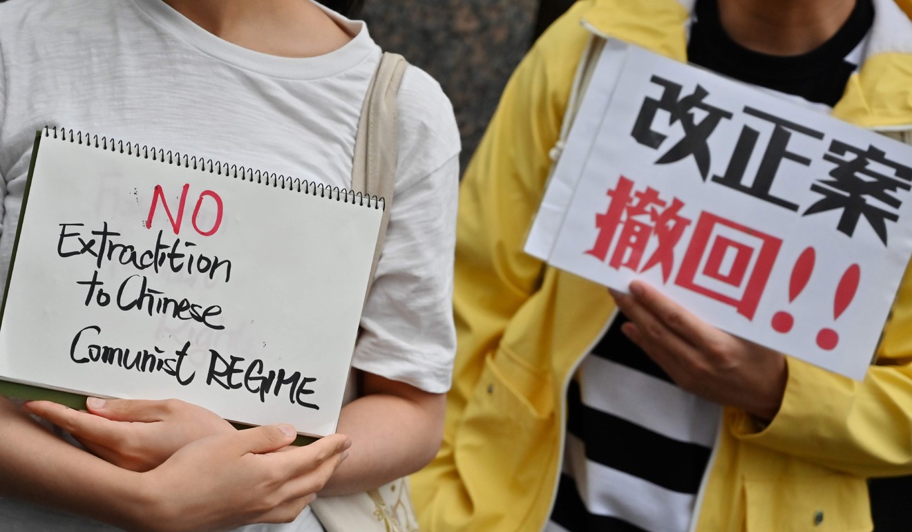 Demonstrators in Tokyo hold placards denouncing the extradition agreement on Sunday. Photo: AFP