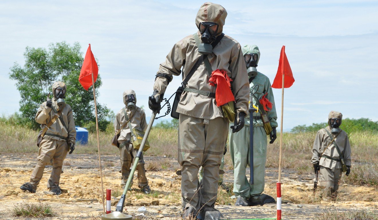 Soldiers in protective gear search for unexploded ordnance near Da Nang. Photo: AFP