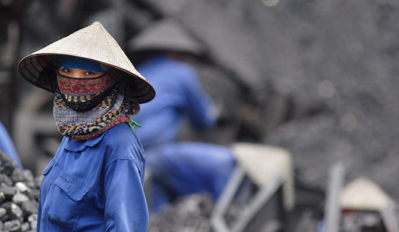 A miner takes a short break from sorting through coal in Uong Bi in Vietnam’s northern Quang Ninh province in April 2007. Photo: EPA