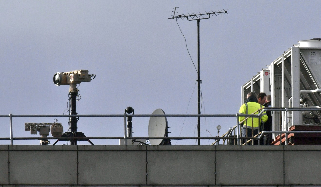 British police installing anti-drone equipment on a rooftop at Gatwick after several drone sightings shut down the airport. Photo: AP