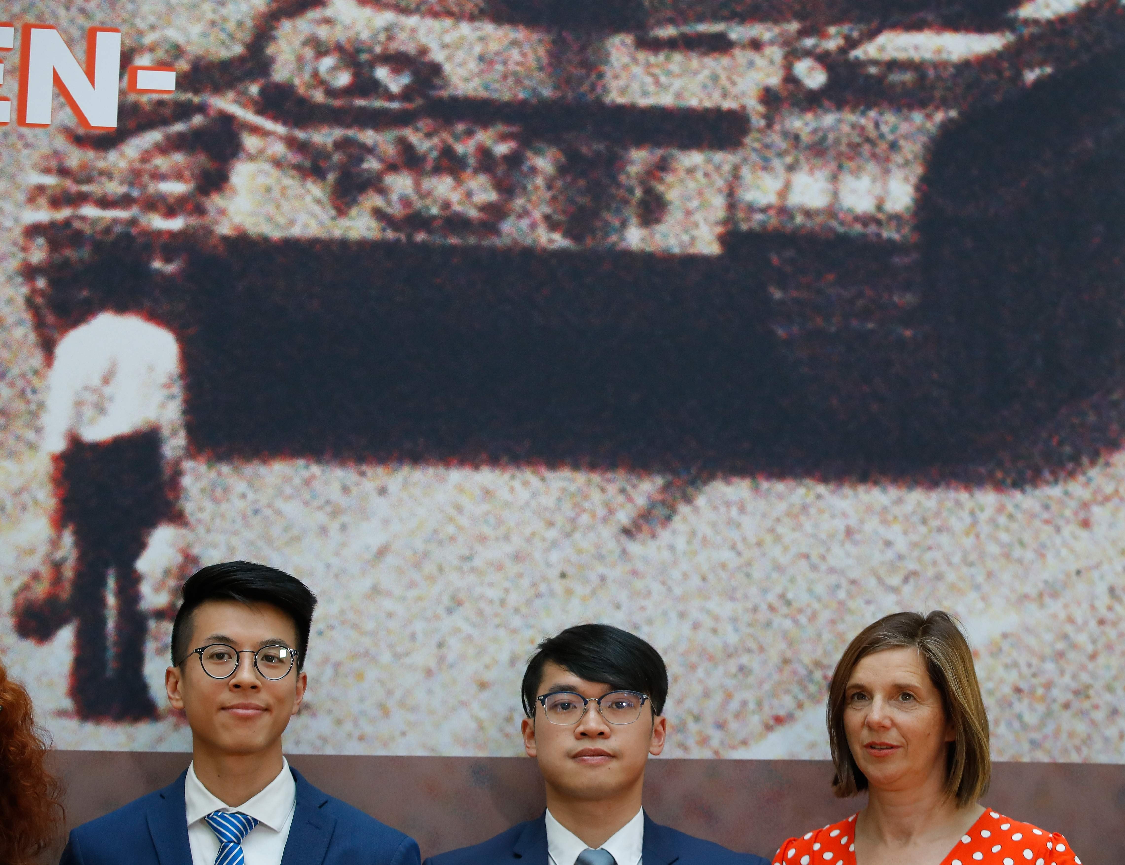 Ray Wong and Alan Li, two activists from Hong Kong who are under refugee protection in Germany, pose with politician Katrin Goering-Eckart at an event in Berlin on June 4, marking the 30th anniversary of the Tiananmen crackdown. In the background is the iconic “Tank Man” photo. Photo: AFP