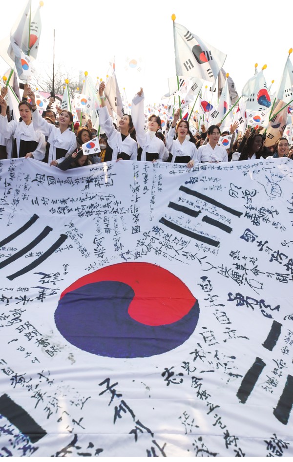 People wave the South Korean flag in front of the Seodaemun Prison History Hall as they re-enact the 1919 movement demanding independence from Japanese colonial rule. Disputes regarding Japan’s colonial era endure today. Photo: EPA