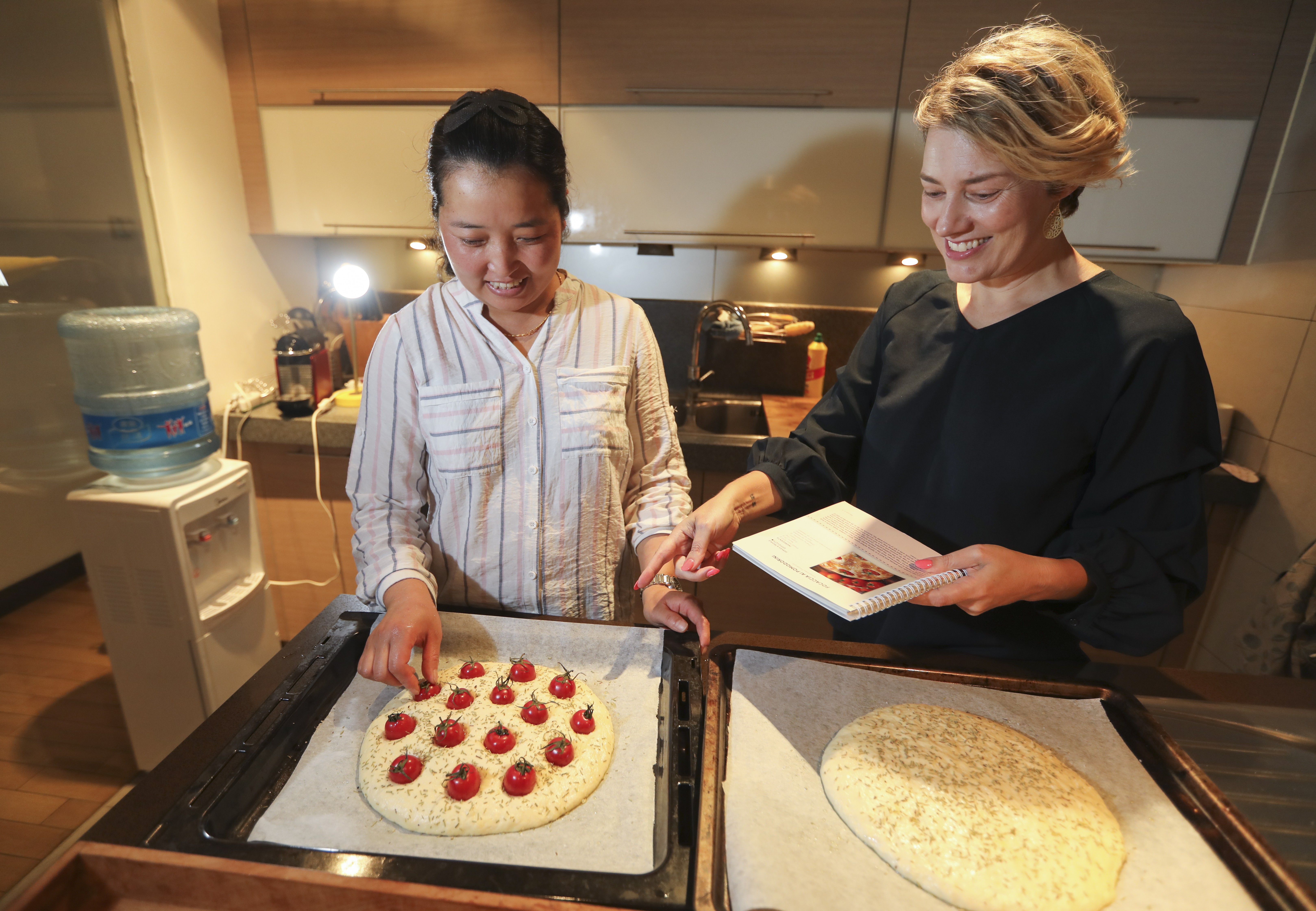 Beijing expat Lise Floris with her ayi Zhang Ting as she cooks focaccia ai pomodorini, or focaccia made with potatoes and cherry tomatoes – a special Italian dish. Photo: Simon Song