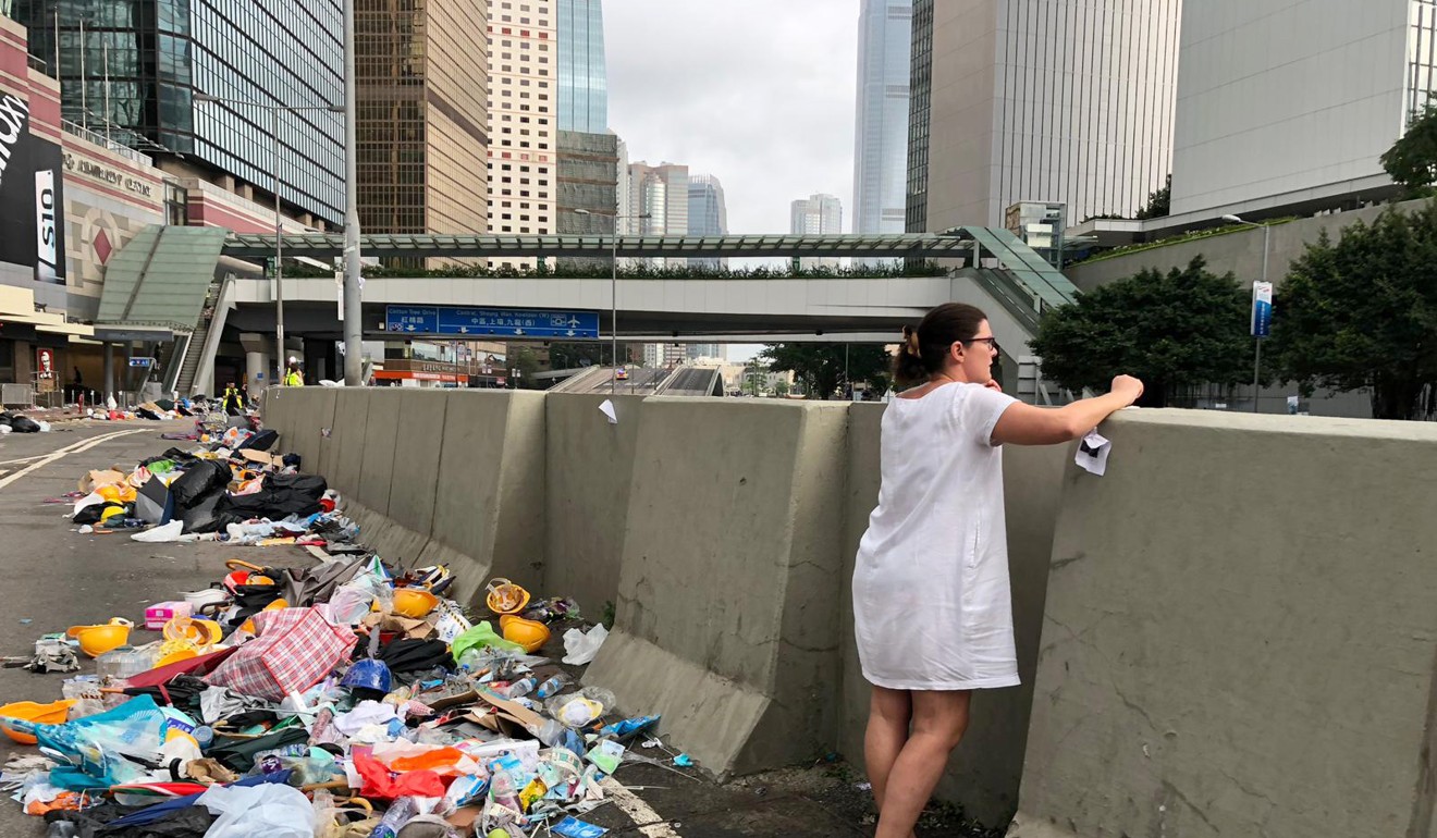 Rubbish litters the road as a woman looks out over Harcourt Road and Gloucester Road. Photo: Robert Ng