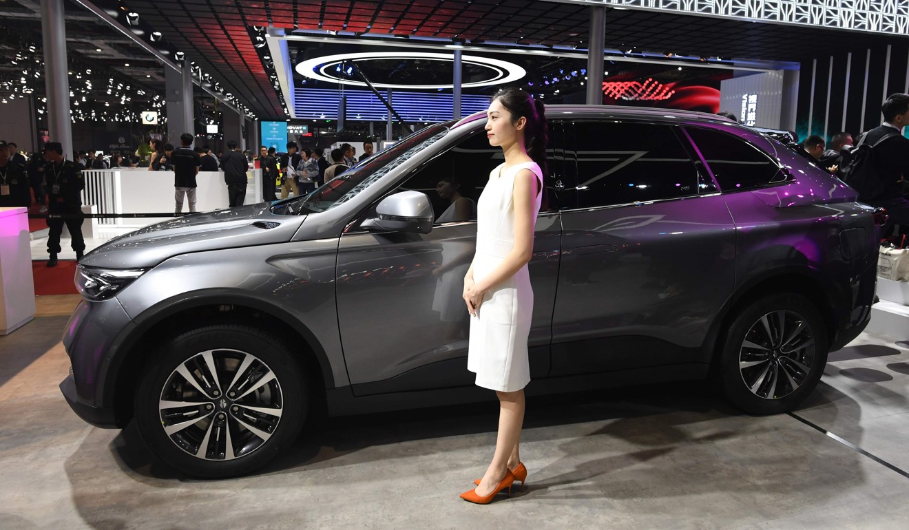 A model stands beside a Singulato iS6 car on the opening day of the Shanghai Auto Show on April 16. China, the world’s largest vehicle market, is facing an unfamiliar sales slump. Photo: AFP