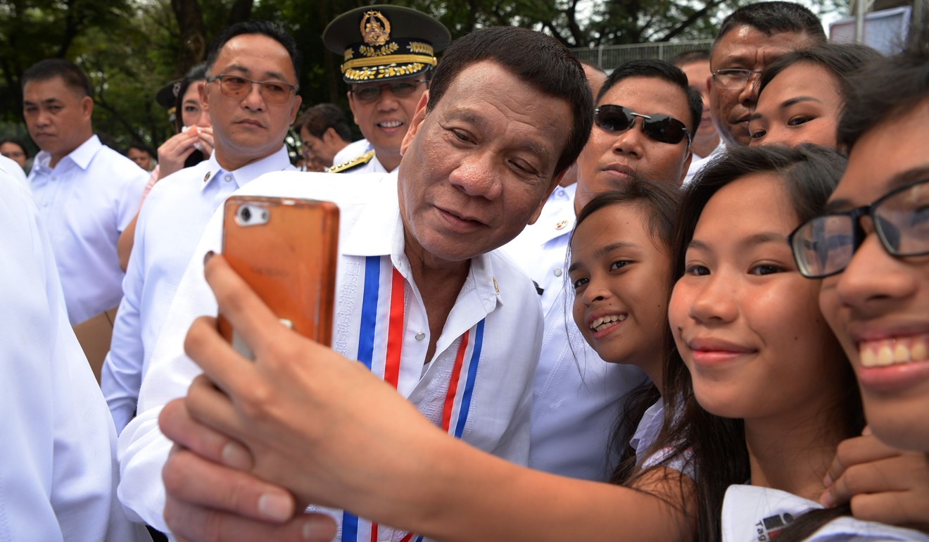 A fan takes a selfie with Philippine President Rodrigo Duterte. Photo: AFP