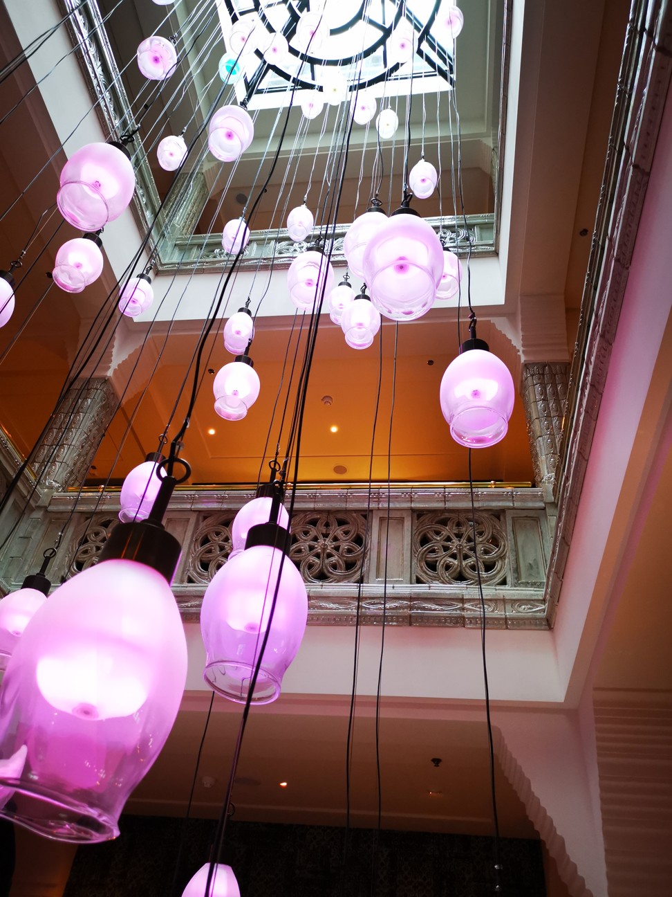 Numerous bright coloured lamps hang from the large central stairwell at the Hotel TwentySeven. Photo: Winnie Chung