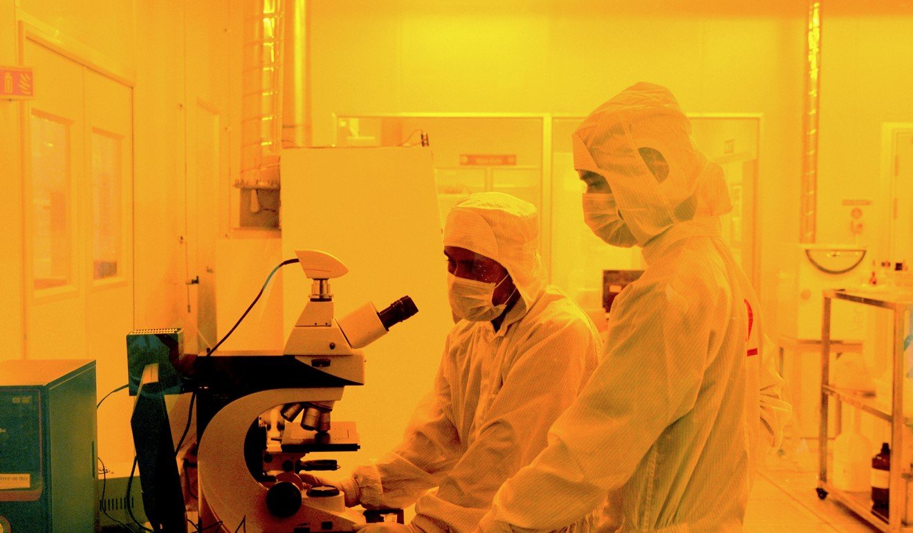 Researchers wearing suits work inside a semiconductor fabrication lab. China is 10 years behind the US in chips, according to one expert. Photo: AFP