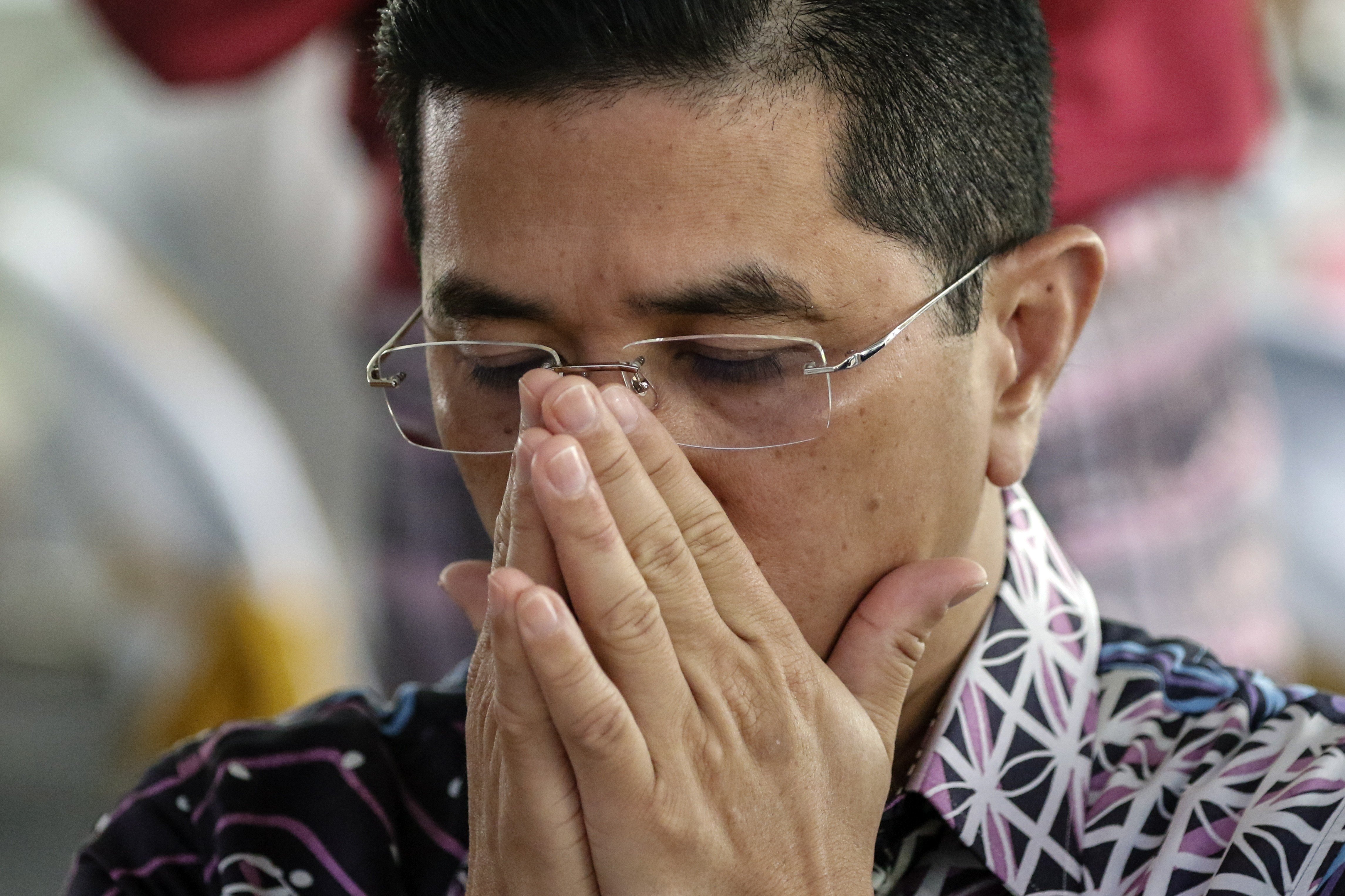 Malaysia’s Economic Affairs Minister Azmin Ali prays at an event at his constituency in Kuala Lumpur. He has denied all the accusations that link him to a sex scandal video. Photo: EPA