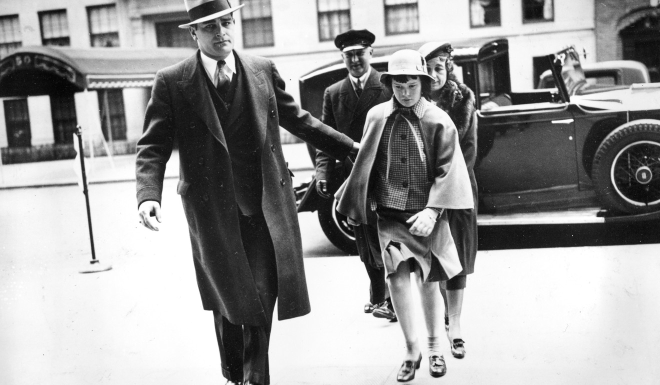 A bodyguard, a nurse and a chauffeur accompany Gloria Vanderbilt into the home of her mother in midtown Manhattan for Easter weekend in 1935. Photo: AP