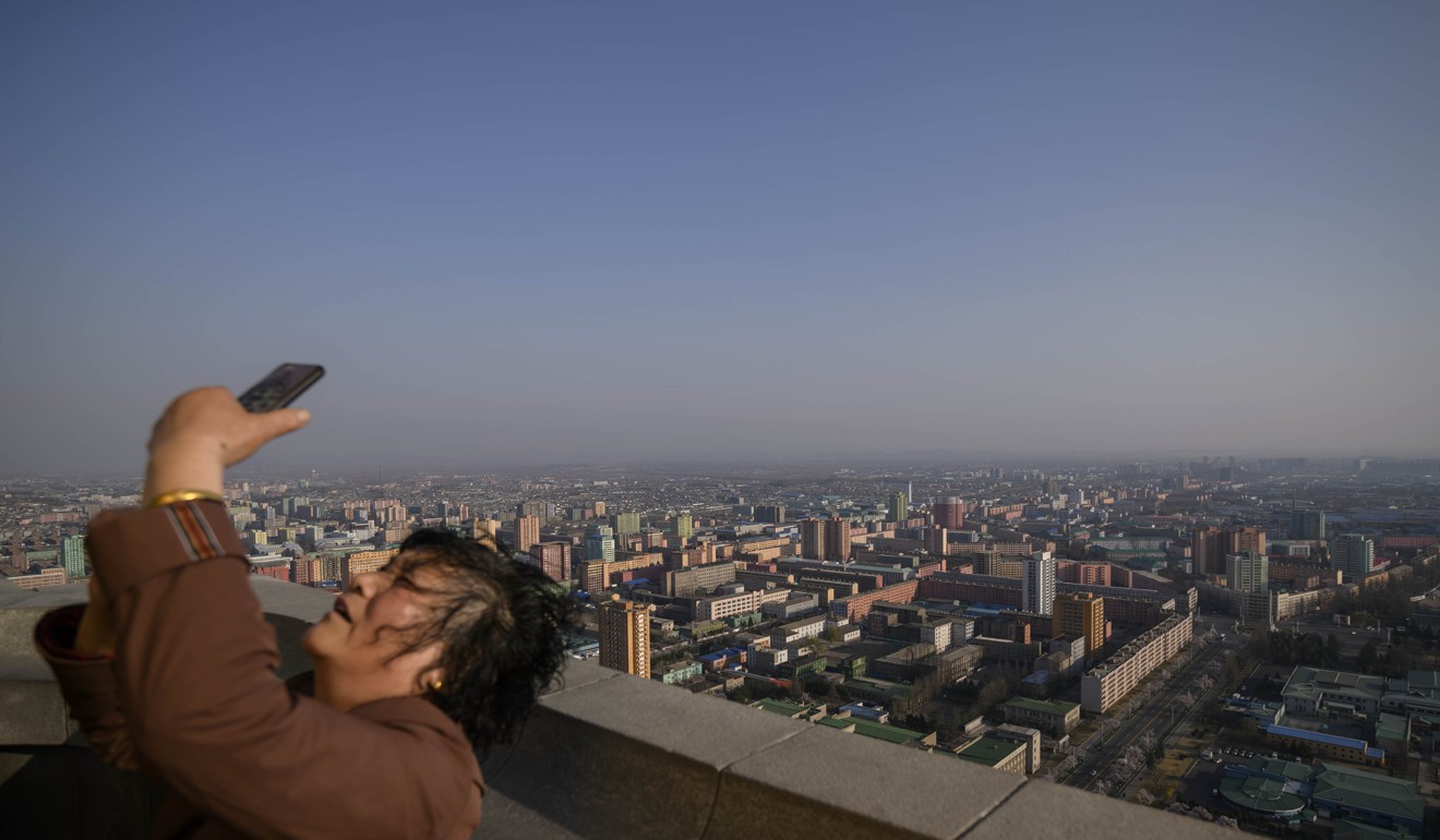 A tourist on a viewing deck of the Juche tower overlooking Pyongyang, which Chinese are travelling to by train in record numbers. Photo: AFP