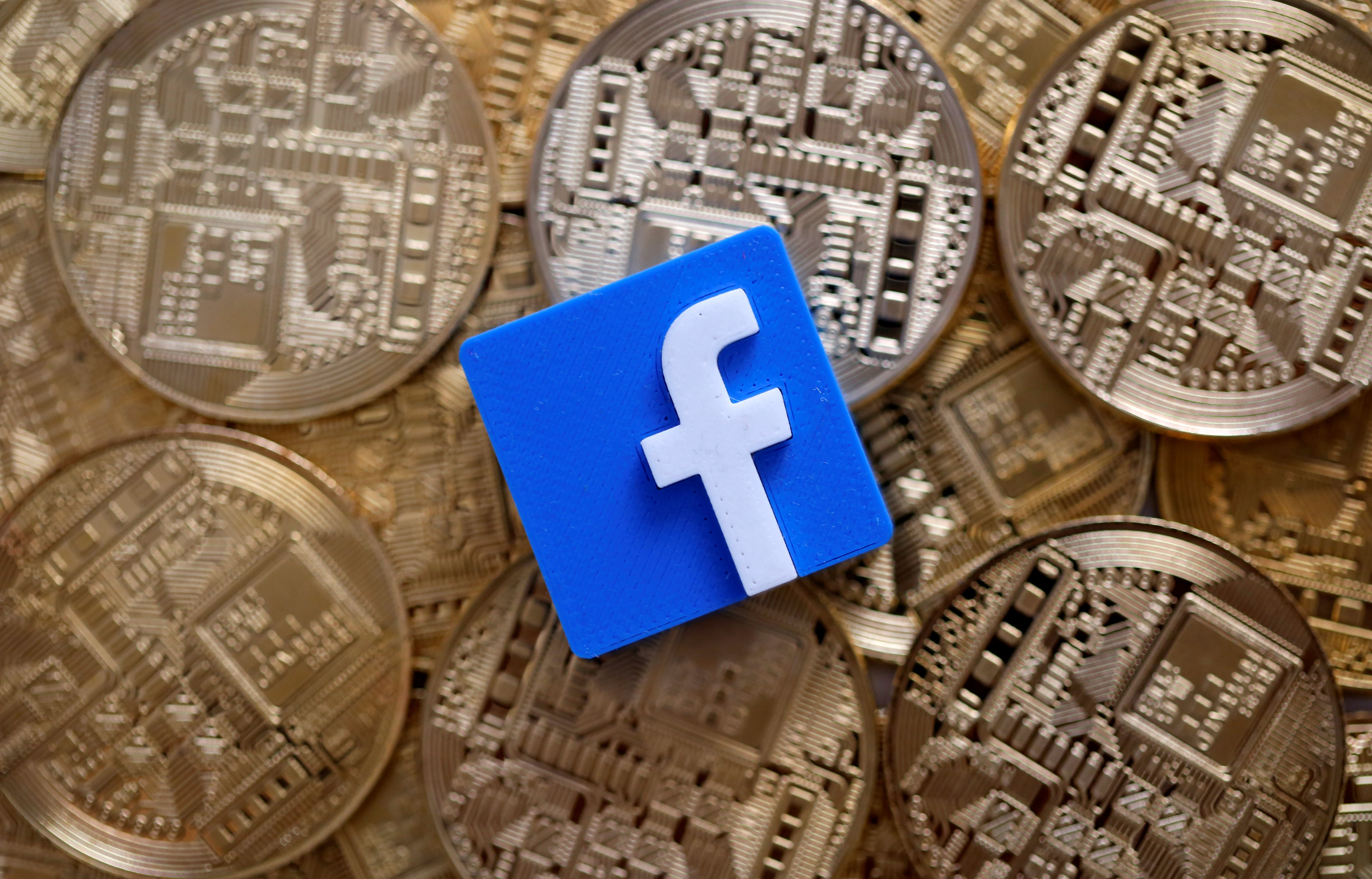 An illustration picture with a 3D printed Facebook logo on top of representations of the bitcoin virtual currency. Photo: Reuters