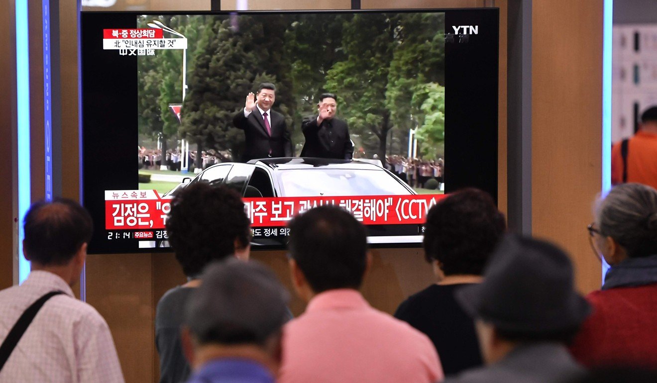People in Seoul, South Korea, watch news coverage of Kim Jong-un and Xi Jinping’s car parade in Pyongyang. Photo: AFP