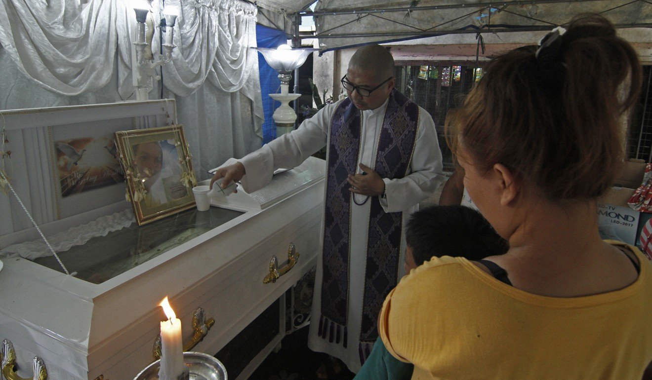 Fr. Flavie Villanueva, SVD, blesses the casket of 34 year old Jerito Garganta after he was shot and killed by unknown assailants along Kawal St., district 28, Caloocan City on the night of May 6, 2019. Photo: Vincent Go