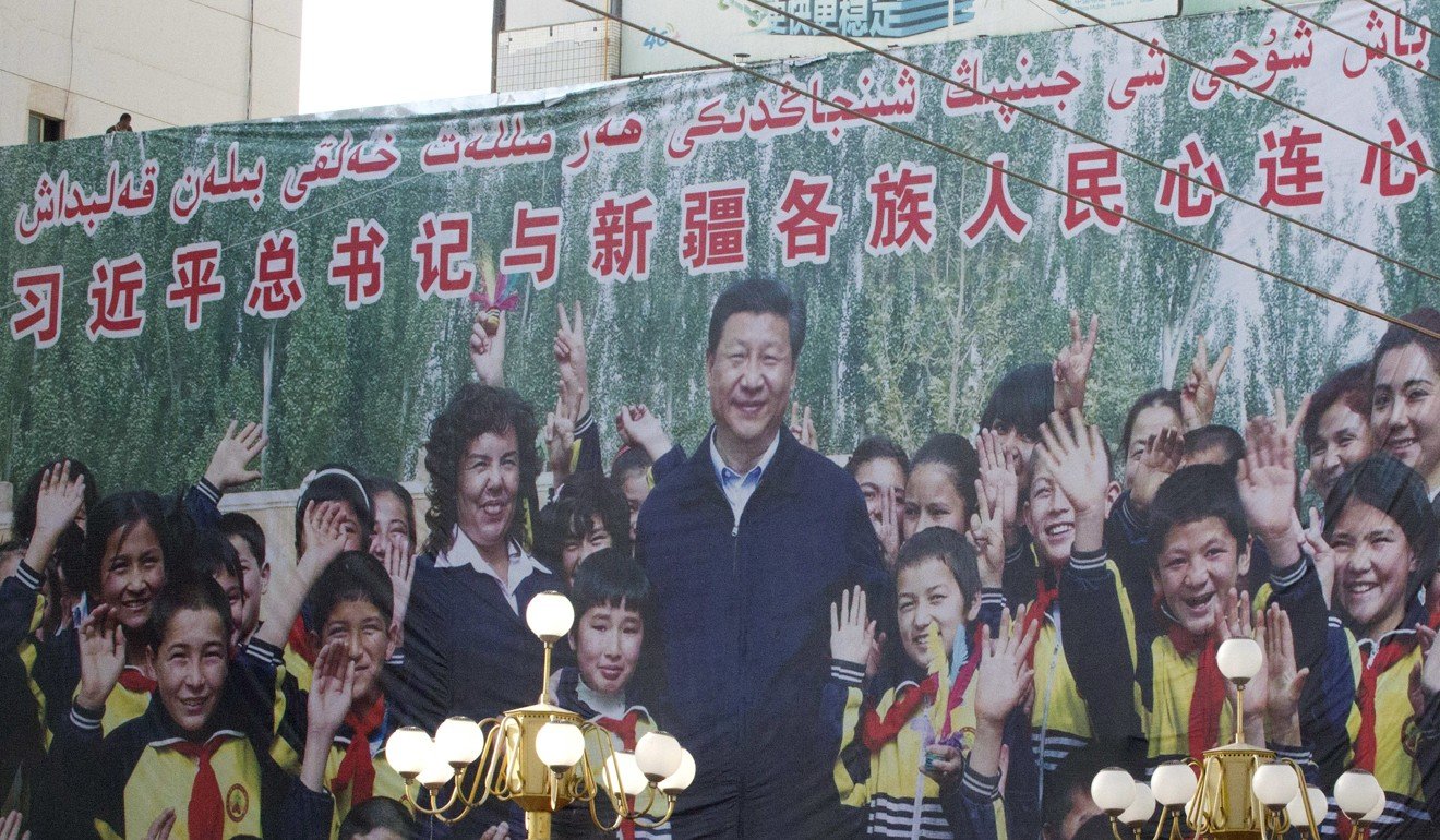 A propaganda poster showing Xi Jinping with ethnic minority children and the slogan “Party Secretary Xi Jinping and Xinjiang’s multi ethnic residents united heart to heart” decorates the side of a building in Kashgar, Xinjiang, in 2018. Photo: AP