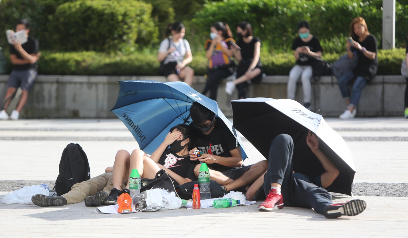 Demonstrators stay hydrated and try to protect themselves from the sun at Tamar. Photo: Winson Wong