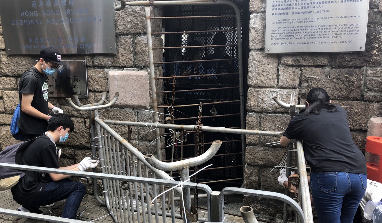 Protesters block the doors of police headquarters in Wan Chai on Friday. Photo: Martin Chan