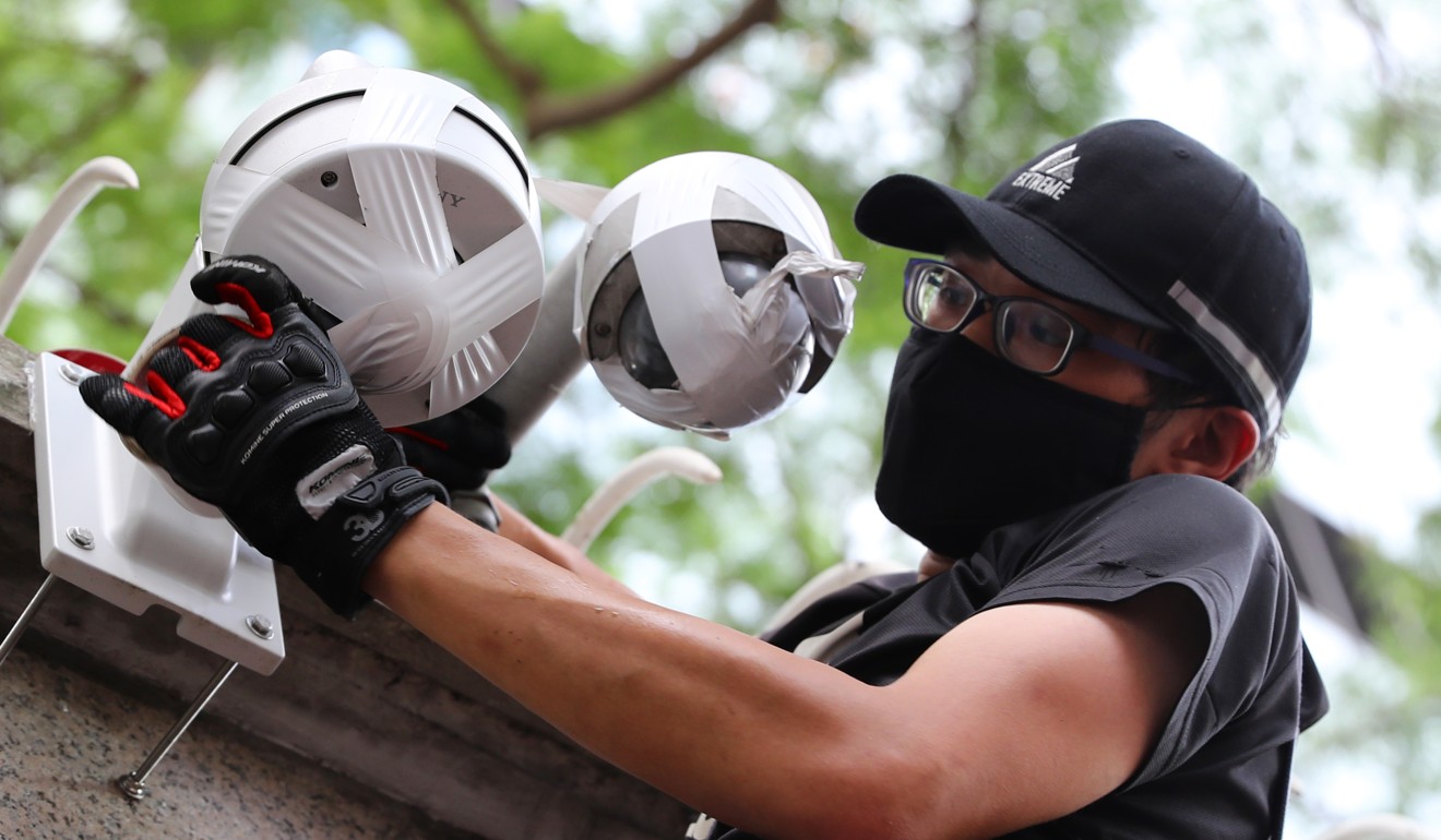 A protester covers up security cameras. Photo: Edmond So