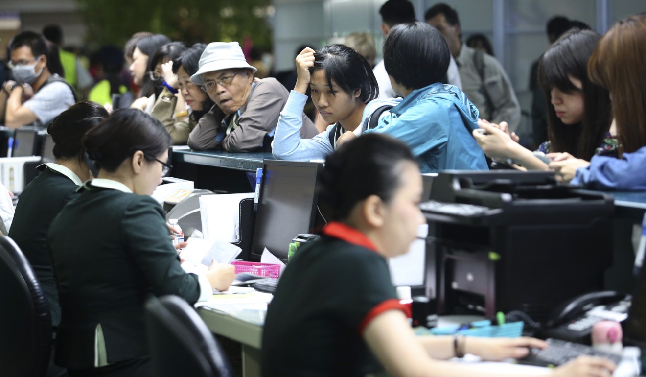 Stranded passengers wait for information at the EVA Air counter at Taoyuan airport in Taiwan on Friday. Photo: AP