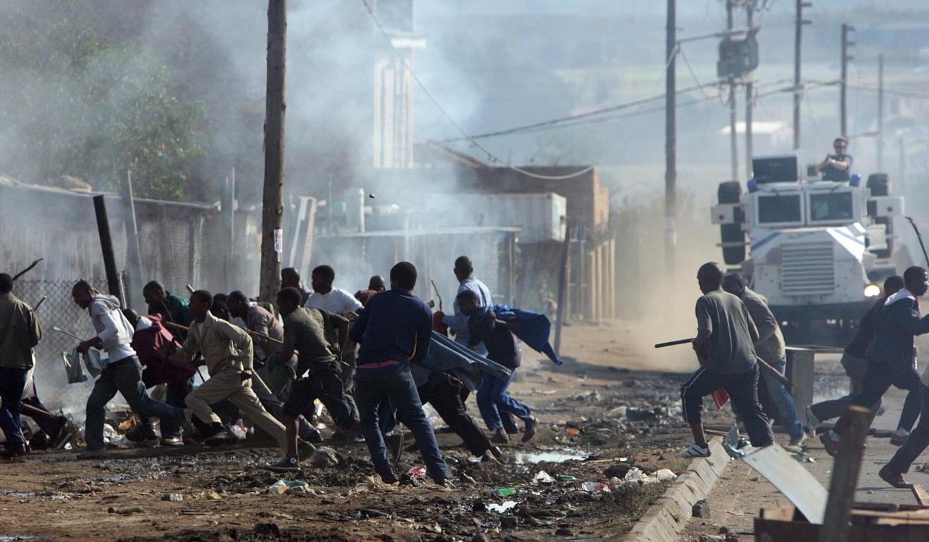 Rioters flee as police open fire in Ramaphosa squatter camp east of Johannesburg in May 2008. Photo: EPA