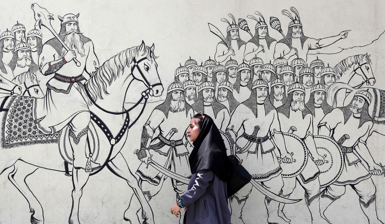 An Iranian woman walks past a mural painting illustrating ancient Persian poetry in the Iranian capital Tehran. Photo: AFP