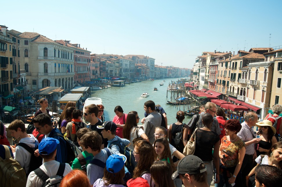 Tourists crowd onto Venice’s Rialto Bridge. Photo: Alamy
