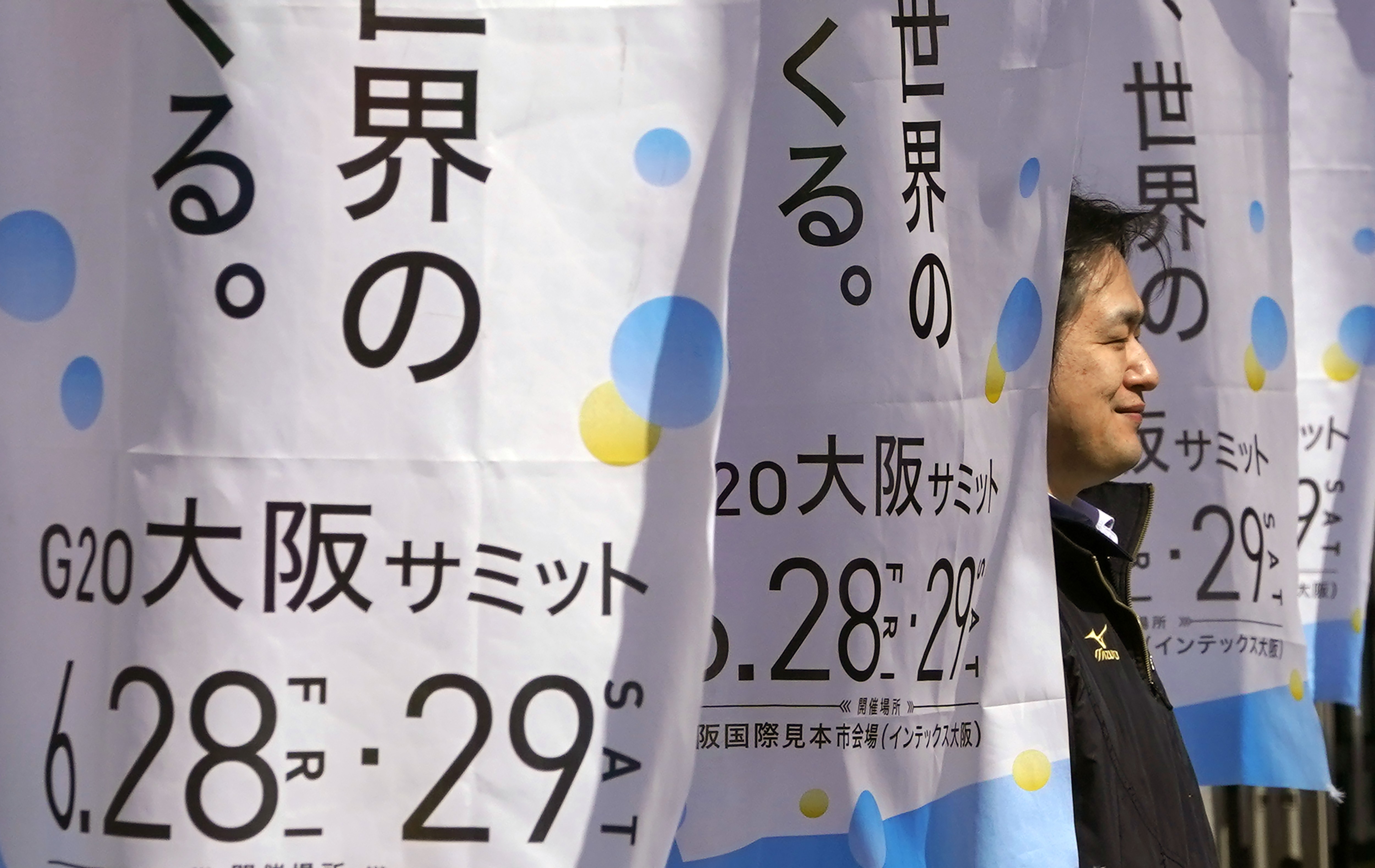 A man walks between advertisements for the G20 summit at the International Exhibition Centre in Osaka, Japan, on May 31. Photo: AP