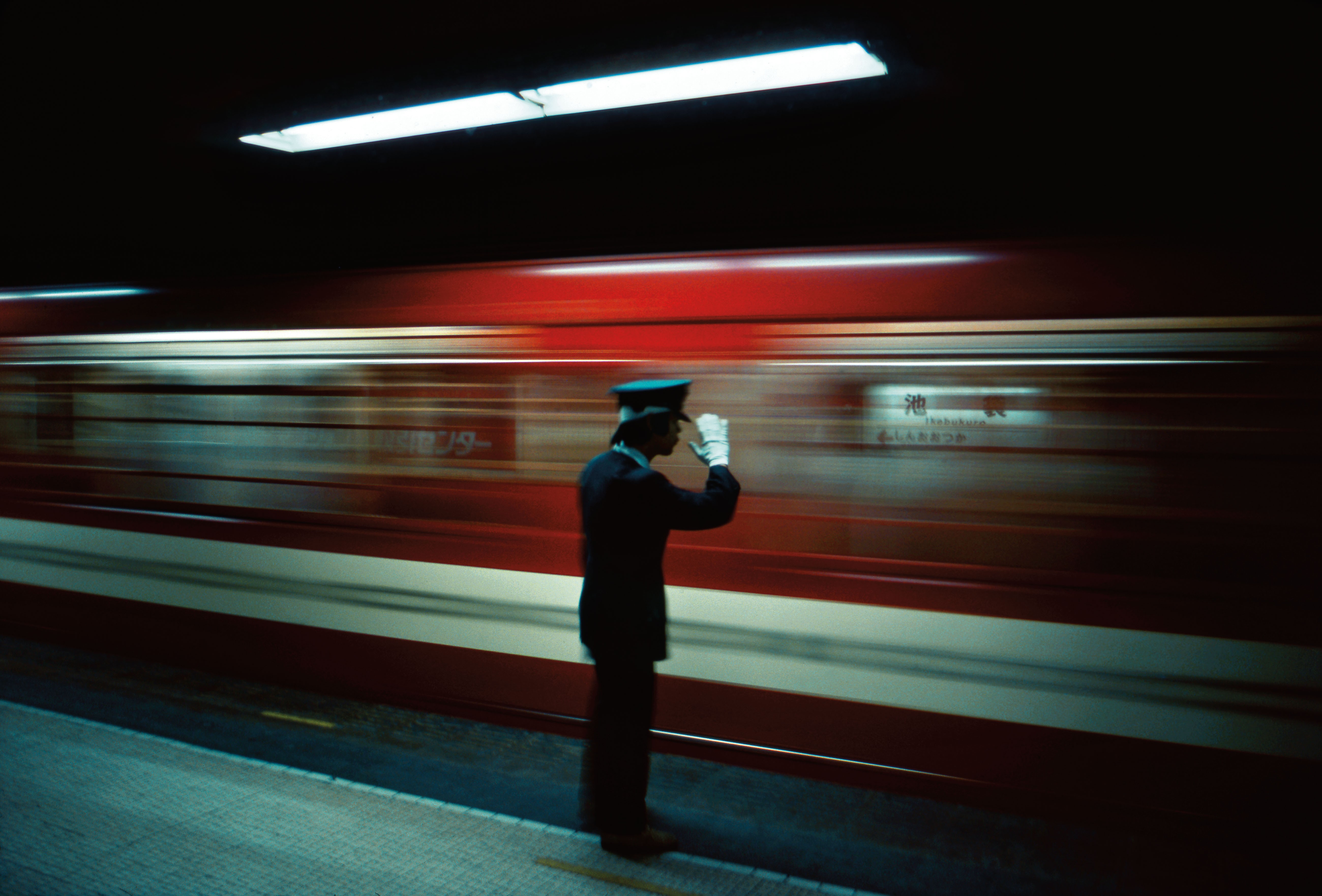 Platform conductor, Ikebukuro Station, Tokyo, 1976. Photo: Greg Girard